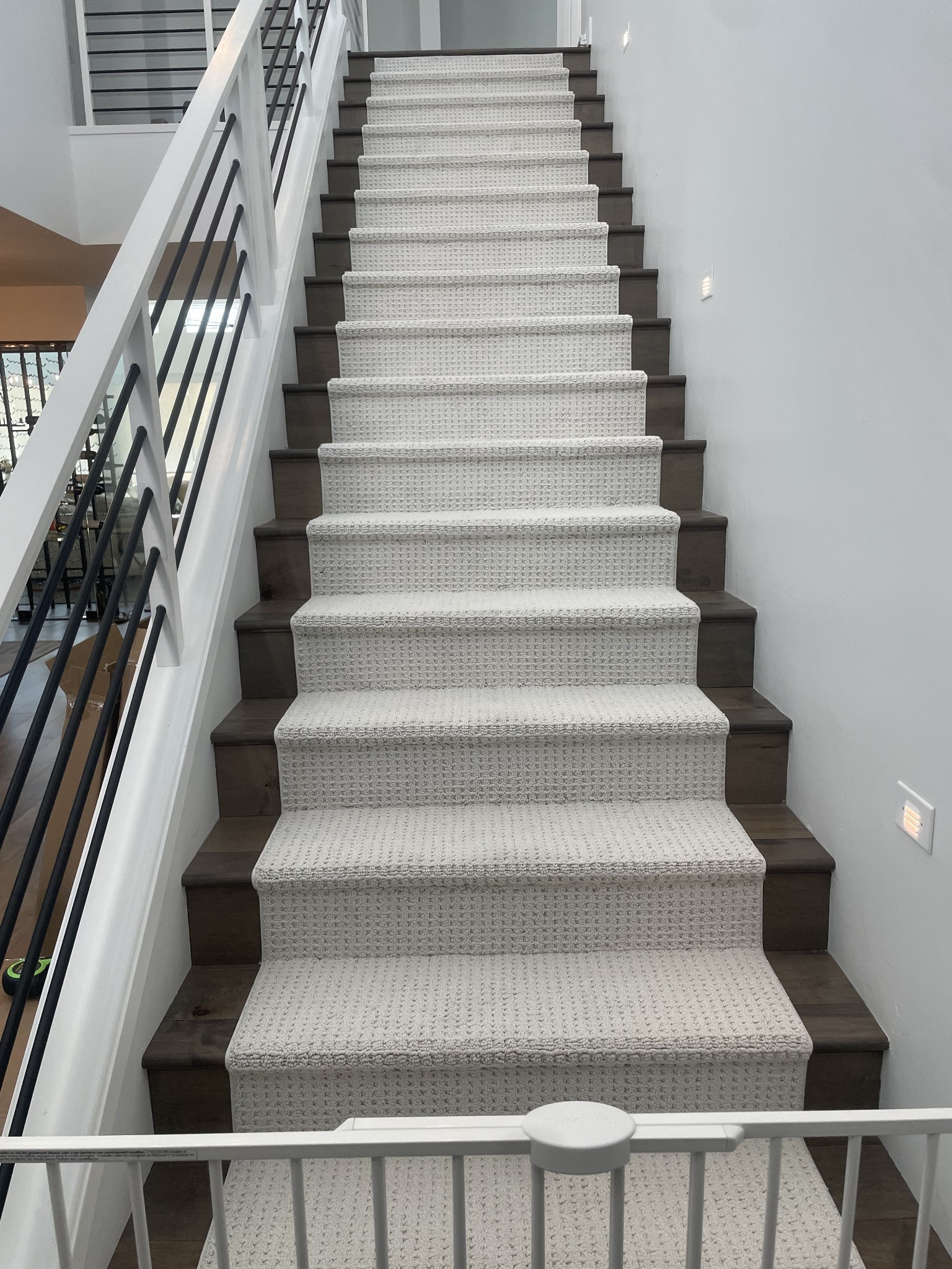 Tailored neutral stair runner installed on a modern open staircase