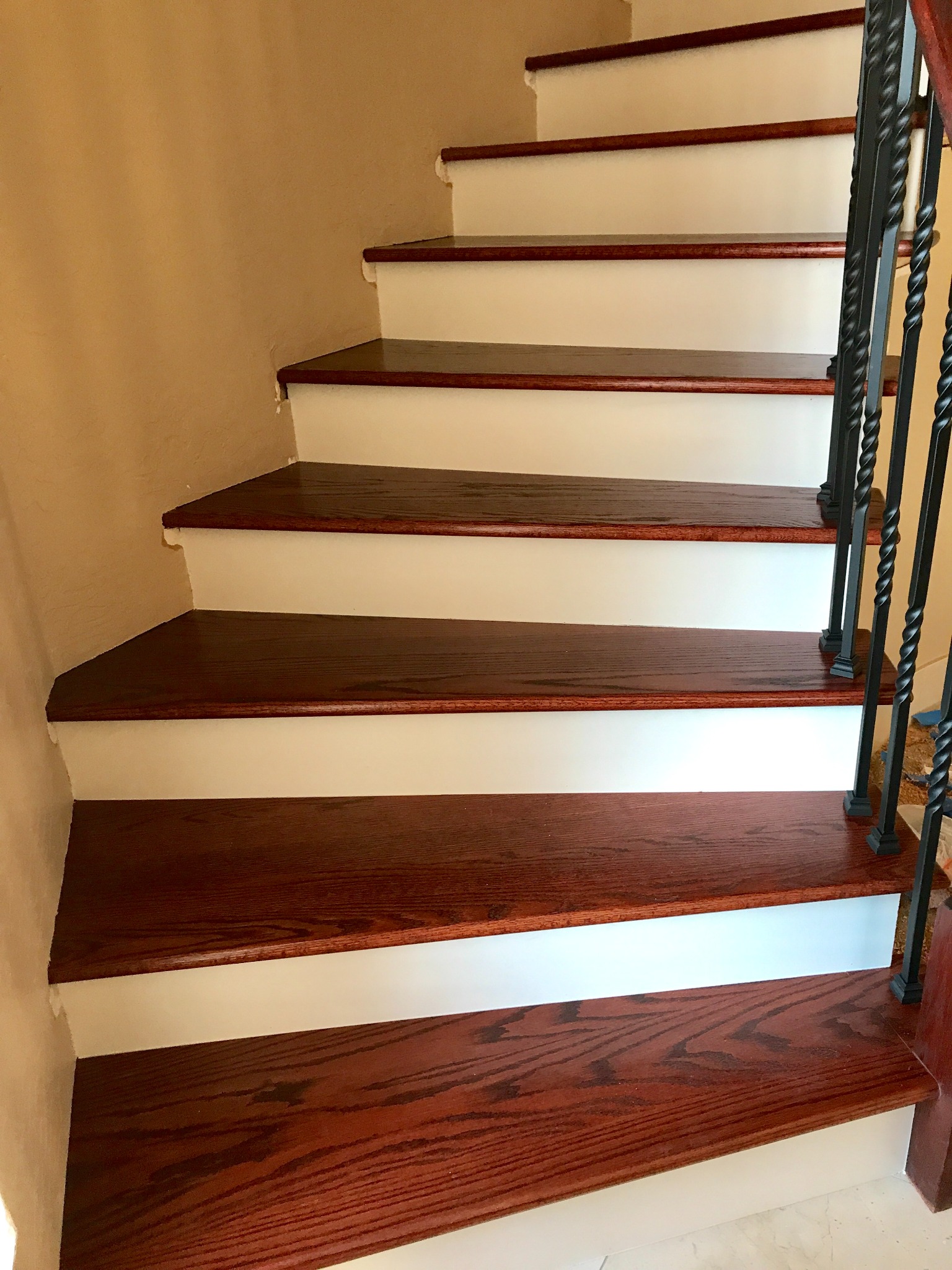 Custom hardwood staircase with individually fitted treads and white risers