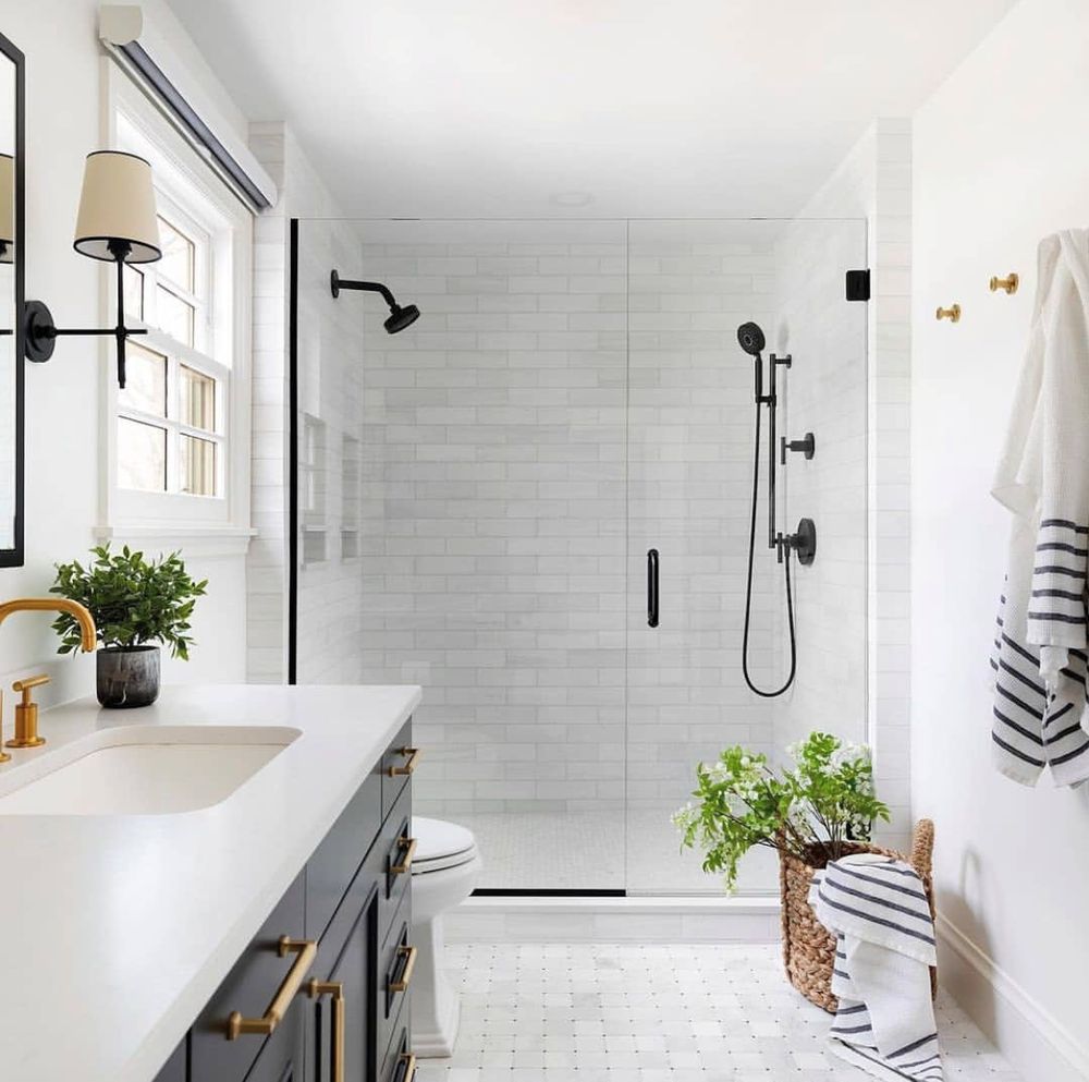 Modern walk-in shower with white tile and matte black fixtures